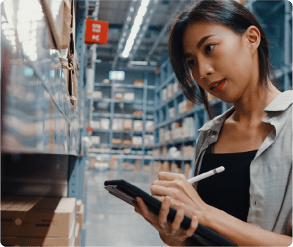 Woman checking inventory in a large warehouse fulfillment center for a large eCommerce store.